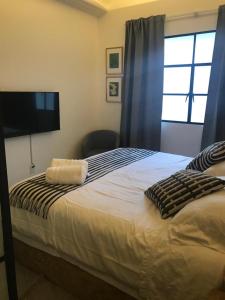 a bedroom with a bed with a flat screen tv at CASA LALIQUE in Mexico City +21 photos