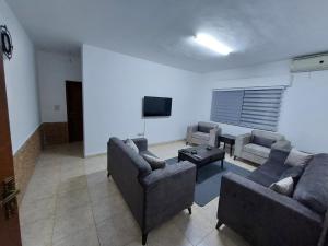 ein Wohnzimmer mit Sofas und einem Flachbild-TV in der Unterkunft Cozy Home in Amman