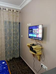 a room with a television on a wall at Gallaghers city ( YameHome ) in Bangangté