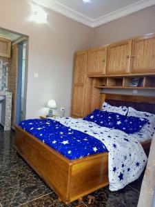 a bedroom with a bed with a blue comforter at Gallaghers city ( YameHome ) in Bangangté