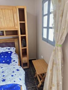 a bedroom with a bed and a window at Gallaghers city ( YameHome ) in Bangangté