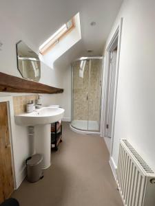 y baño con lavabo y ducha. en Immaculate barn annexe close to Stansted Airport, en Great Dunmow