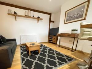 a living room with a couch and a table at Immaculate barn annexe close to Stansted Airport in Great Dunmow