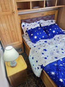a bed with blue and white sheets and a lamp at Gallaghers city ( YameHome ) in Bangangté