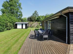 ジルレジェにあるThree-Bedroom Holiday home in Gilleleje 14の木製デッキ(テーブル、椅子付)