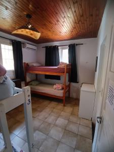 a small room with two bunk beds and a wooden ceiling at Cataratas Jazz Hostel in Puerto Iguazú