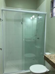 a glass shower in a bathroom with a toilet at Hotel Casa Branca in Uruguaiana