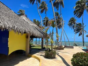 un complejo con palmeras y el océano en el fondo en Eco Paradise ap 122, en Cumbuco