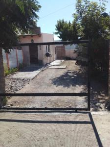a gate in front of a house with a yard at Aldos in San Antonio Oeste