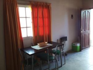 d'une salle à manger avec une table, des chaises et une fenêtre. dans l'établissement Aldos, à San Antonio Oeste