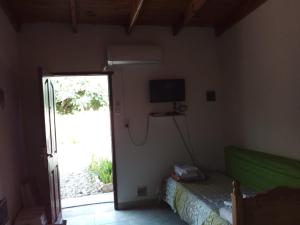 a bedroom with a bed and a television and a sliding door at Aldos in San Antonio Oeste