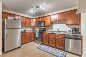 a kitchen with wooden cabinets and stainless steel appliances at ConTemporary Stay in Central Peoria in Peoria