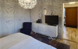 um quarto com uma cama, uma televisão e uma cadeira em 4 Bedroom Gorgeous Home In Varberg em Varberg