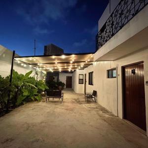 a patio with a bench and lights on a building at Aldeazul by Andiani Travel in Cancún