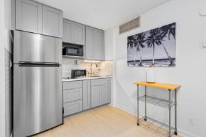 a kitchen with a stainless steel refrigerator and a table at Hale Kekai on Bishop 2412 - 30-Day Minimum in Honolulu