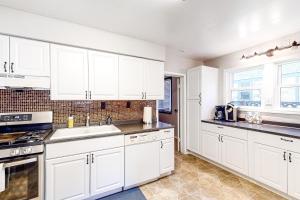 una cucina bianca con armadietti e elettrodomestici bianchi di The Perfect Sandpoint Rental a Sandpoint