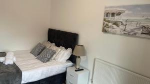 - une chambre avec un lit et une lampe sur une table de chevet dans l'établissement POTTERS LODGE by Edl Ventures Ltd, à Manchester