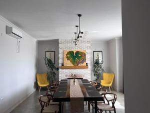 a dining room with a table and yellow chairs at Begaso Family Winery in Kvareli