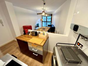 uma cozinha com um balcão de madeira num quarto em Loft Fuentes em Felechosa