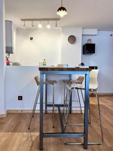 a blue table in a kitchen with stools at Loft Fuentes in Felechosa
