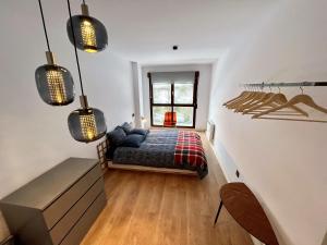 1 dormitorio con 1 cama en una habitación con ventana en Loft Fuentes, en Felechosa