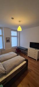 1 dormitorio con 2 camas, mesa y TV en 2Zimmer Apartment mit Stellplatz, en Krefeld