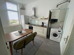 een keuken met een tafel en een wasmachine bij 2Zimmer Apartment mit Stellplatz in Krefeld