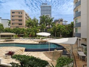 a pool with chairs and umbrellas and buildings at Points North in Caloundra
