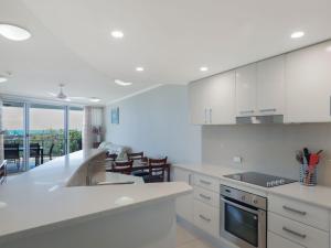 a white kitchen with a sink and a counter at Points North in Caloundra