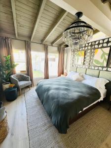 Un dormitorio con una cama grande y una lámpara de araña. en A PLACE IN THE SUN Hotel - ADULTS ONLY Big Units, Privacy Gardens & Heated Pool & Spa in 1 Acre Park Prime Location, PET Friendly, TOP Midcentury Modern Boutique Hotel, en Palm Springs