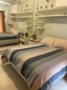 1 dormitorio con 2 camas y estanterías en Departamento Camba Cua en Corrientes