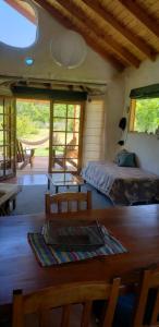 1 dormitorio con 1 cama, mesa y sillas en Casa cerca del lago en Lago Puelo