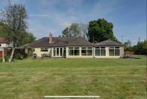 a house with a large lawn in front of it at Fabulous Spacious Bungalow in Solihull close to Bham Airport NEC & Bham City Centre in Knowle