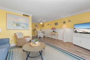 a living room with a couch and a tv at Bent Palm 218 in Ormond Beach
