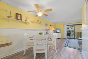 a dining room with a ceiling fan and a table and chairs at Bent Palm 218 in Ormond Beach +27 photos