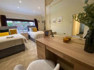 a bedroom with two beds and a large mirror at Fabulous Spacious Bungalow in Solihull close to Bham Airport NEC & Bham City Centre in Knowle