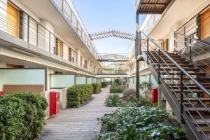 un couloir d'un immeuble avec un escalier et des plantes dans l'établissement Studio Nuitée en Provence 2, à Aix-en-Provence