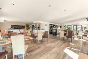 a dining room with tables and chairs and a kitchen at Studio Nuitée en Provence 2 in Aix-en-Provence