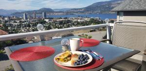 einen Teller mit Essen auf einem Tisch auf einem Balkon in der Unterkunft Vacation Lake View House kelowna BNB in Kelowna