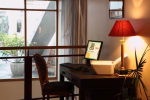 a desk with a computer and a lamp and a window at Amiral Hôtel in Paris