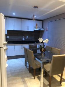 a dining room with a black table and chairs at CASA NO BORGO MOBILIADA in Bento Gonçalves