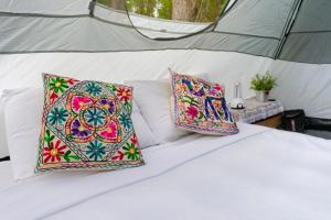 duas almofadas numa cama numa tenda em OM B&B + Spa em Viamão
