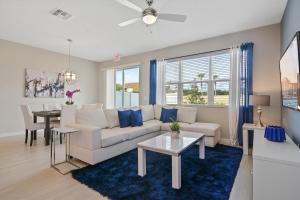 uma sala de estar com um sofá branco e um tapete azul em Family Friendly Four Bedrooms 5145 em Kissimmee