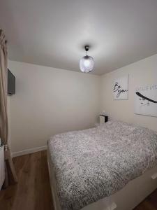 Un dormitorio con una cama y una luz en la pared. en Apparte/Hotel de Luxe, en Melun
