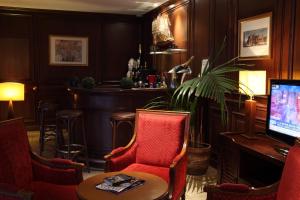 a bar with chairs and a table and a television at Amiral Hôtel in Paris
