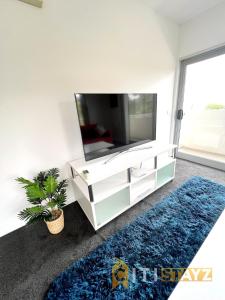 a living room with a tv and a blue rug at Bold in Bruce - 1bd 1bth 1csp in Belconnen