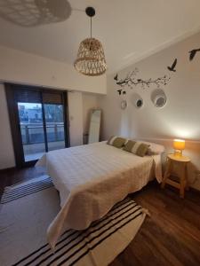 Un dormitorio con una cama grande y una lámpara de araña. en Departamento Categoria Centro By Lofter en La Plata