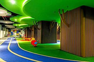 une chambre dotée d'un couloir avec des plafonds verts et une voiture à jouets dans l'établissement Apartment Embarcadero Bintaro Suites by Novie Mckenzie, à Pondokaren