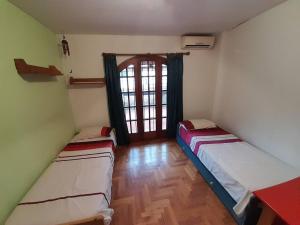 two beds in a room with a window at Departamento en Olivos in Olivos