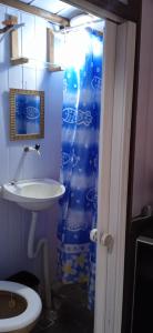 a bathroom with a sink and a shower curtain at Pousadinha da LIZA E HOSTEL in Mangaratiba